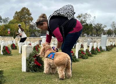 Allison and Mokka placing a wreath at a veterans cemetery