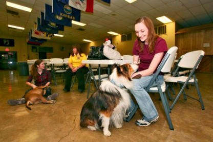 A Paws 4 Hearts therapy team greeting residents in the common room of a care facility